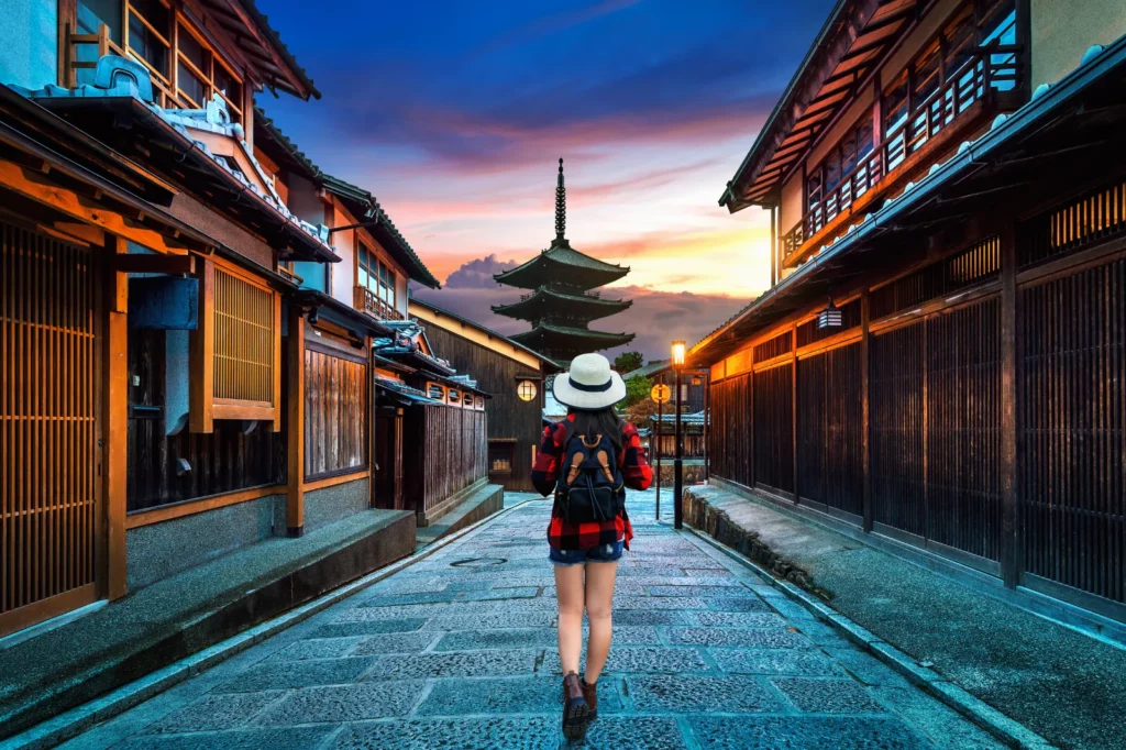 Voyageuse marchant dans une ruelle de Kyoto vers la pagode Yasaka au coucher du soleil