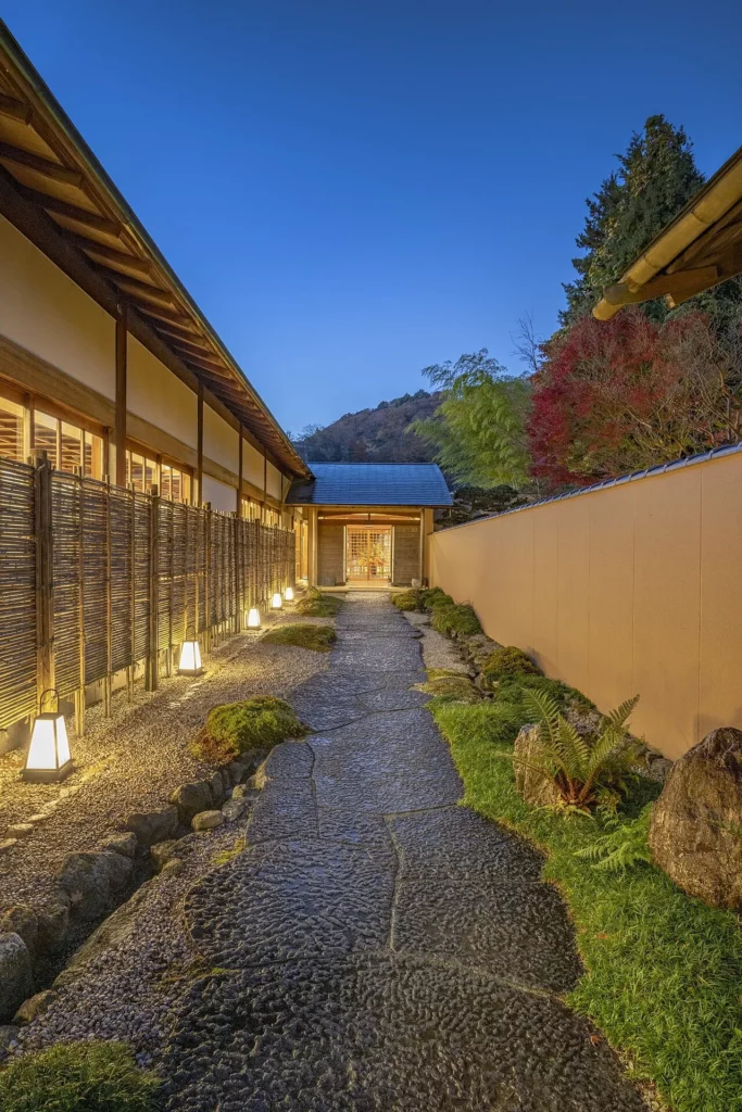 Allée d’entrée éclairée du ryokan Gora Kadan à Hakone, au crépuscule