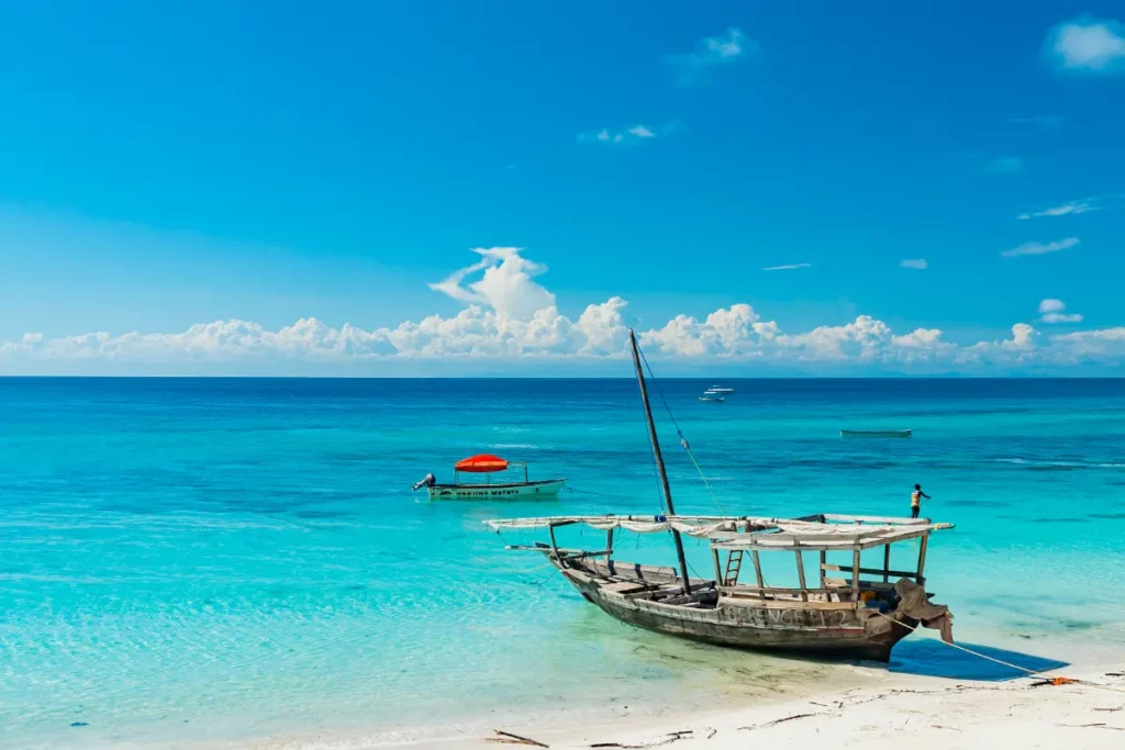 Boutre sur une plage de sable blanc à marée basse, à Zanzibar